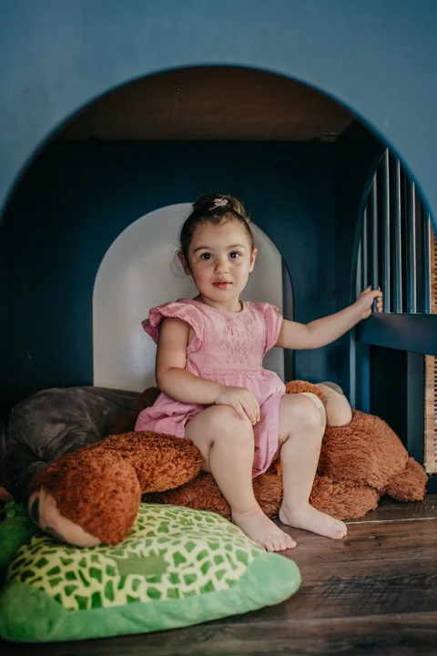 Een kind zit knus in de leeshoek met een knuffelbeer