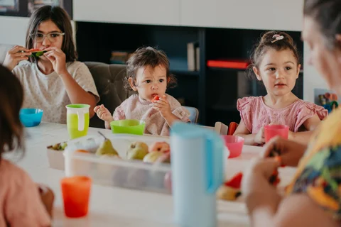 Kinderen eten samen fruit aan tafel