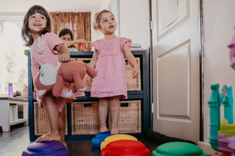 Een kind staat bij de opbergkasten in de woonkamer