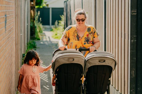 De gastouder vertrekt met de dubbele wandelwagen voor een wandeling
