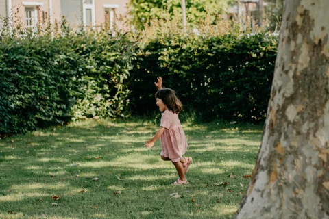 Een kind rent over het gras in het park