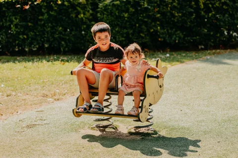 Twee kinderen spelen samen op de wip in het park