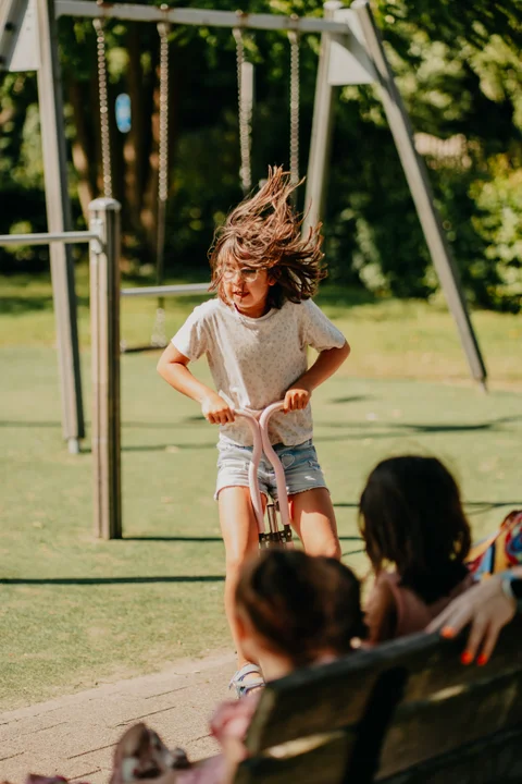 Een kind rijdt op een step in het park